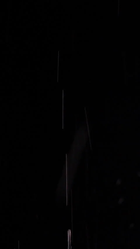 Vertical video. Clear Water Streams Fall Against a Black Background, Creating a Stock Footage 341412835