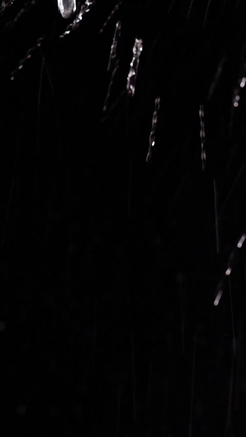 Vertical video. Clear Water Streams And Droplets Fall Against a Black Background Stock Footage 341422855