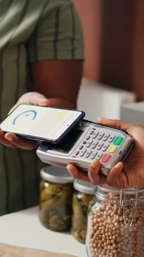 Vertical Video Client buying produce using nfc mobile payment at pos Stock Footage 262046443
