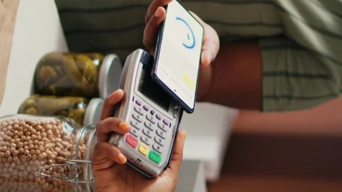Vertical Video Client buying produce using nfc mobile payment at pos Stock Footage 262283075