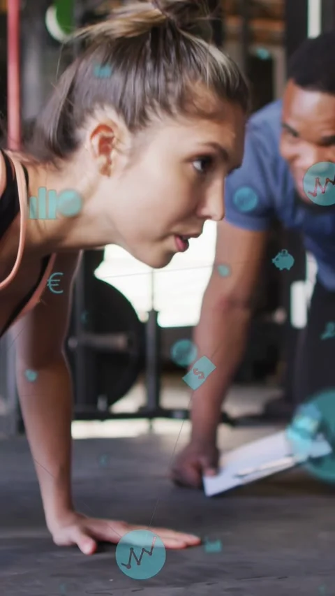 Vertical video: Client doing pushups in gym, coach tapping pad sparking icons Stock Footage 335513428
