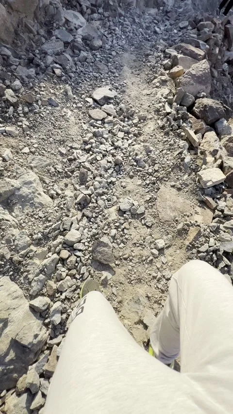 Vertical video of climbing swiftly down loose rocks on a mountain hike Stock Footage 166089055