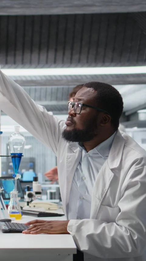 Vertical video Clinical microbiologist in lab looking at blood sample in test Stock Footage 319507152