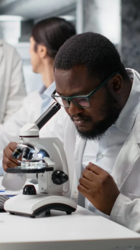 Vertical video Clinical microbiologist operating compound microscope, recording Stock Footage 319506743