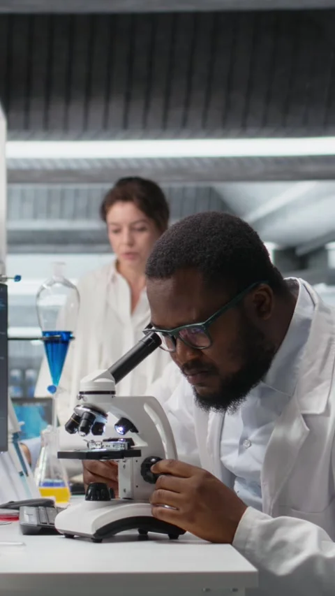 Vertical video Clinical microbiologist operating compound microscope, recording Stock Footage 319506957