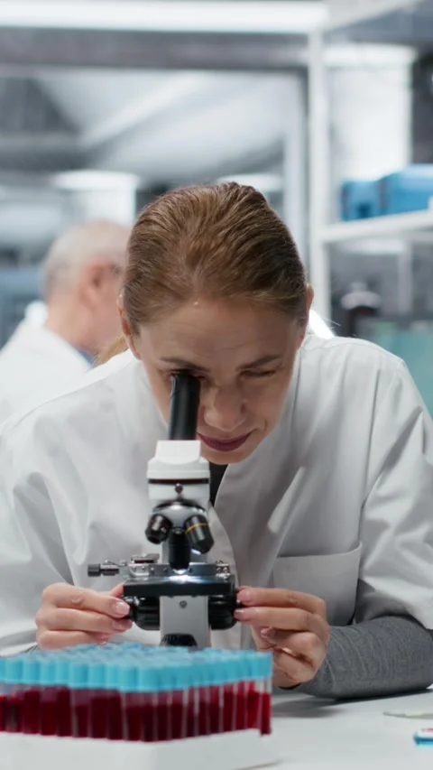 Vertical video Clinical microbiologist using compound microscope for detailed 库存影片 326259335