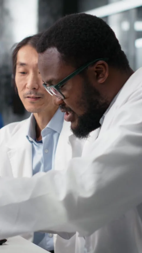 Vertical video Clinical microbiologists using microscope to evaluate cellular Stock Footage 319718295