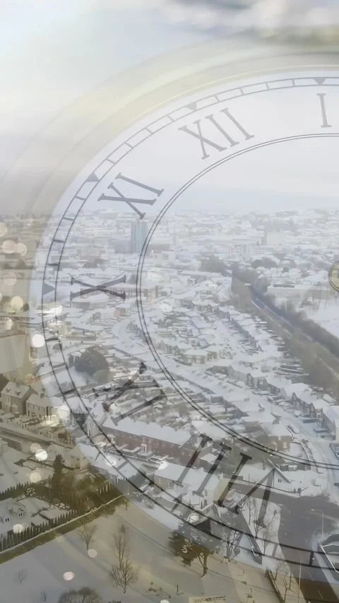 Vertical video: Clock hand starting, clock face sweeping, fading snow town into Stock Footage 329613206