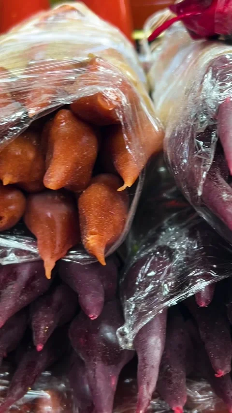 Vertical video close up. 60 fps. Stall with georgian dish juicy red churchkhela Stock Footage 321287916