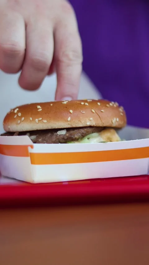 Vertical video close up. 60 fps. Male hand touch burger in box Stock Footage 340428099