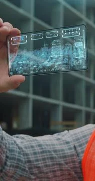 Vertical video. Close up Architect or Engineer using smartphone transparent h Stock Photos