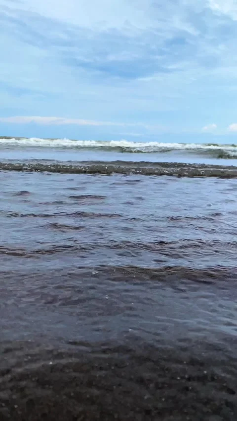 Vertical video Close-up of blue Ocean Waves on Sandy Beach with blue sky. 4K Vidéo 301449880
