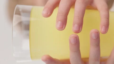 Vertical video. Close-up. The boy takes a glass of lemonade with both hands. Video stock 275039448