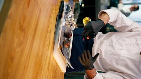Vertical video close-up the chef stands in the kitchen in white jacket and Stock Footage 273481203