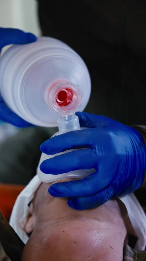 Vertical video close-up of a confident man in blue medical gloves pumping air Stock Footage 273536752