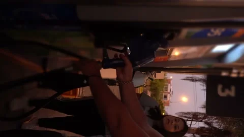 Vertical video close-up a couple pulling out a fuel gun in the car at the gas st 库存影片 198756843