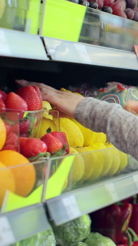 Vertical video. Close up Curly-haired worker stocking lemons in supermarket. Stock Footage 346683710