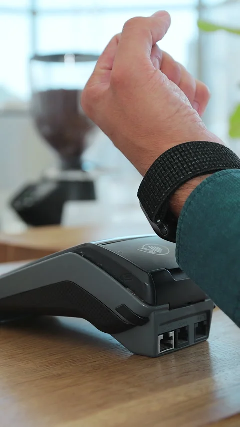 Vertical video. Close up customer for coffee paying with an NFC  smartwatch Stockbeeldmateriaal 343768275
