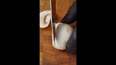 Vertical video. Close-up of cutting fresh champignon mushrooms. Video stock 302636573