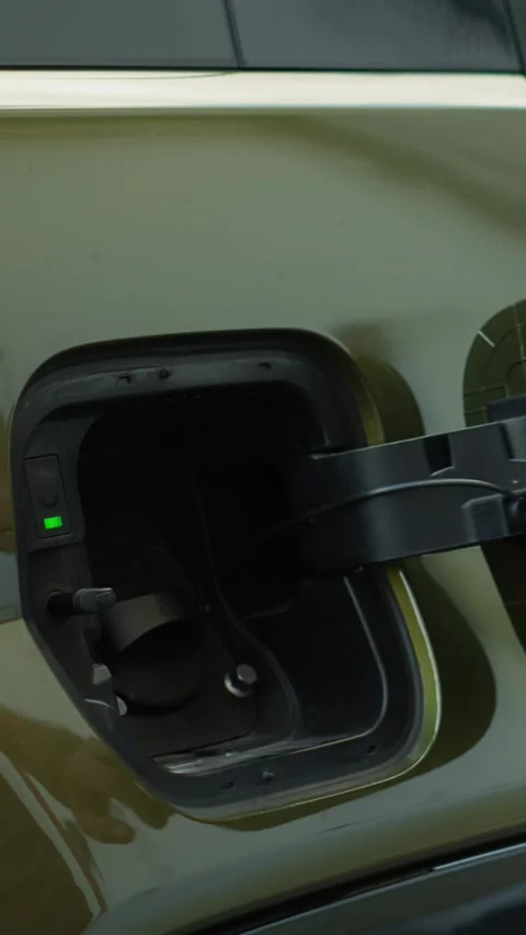 Vertical video Close up of driver connecting EV plug to electric car to recharge Stock Footage 315999331