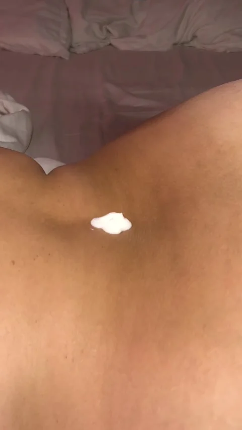 Vertical video close up. Drop of white cream drips onto female back Stock Footage 280484293