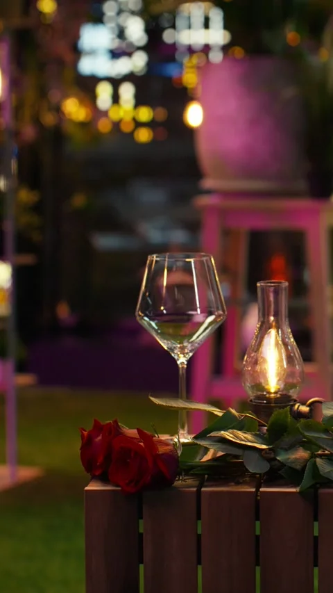 Vertical video Close up of empty wine glasses, lamp and roses on restaurant Stock Footage 347085115