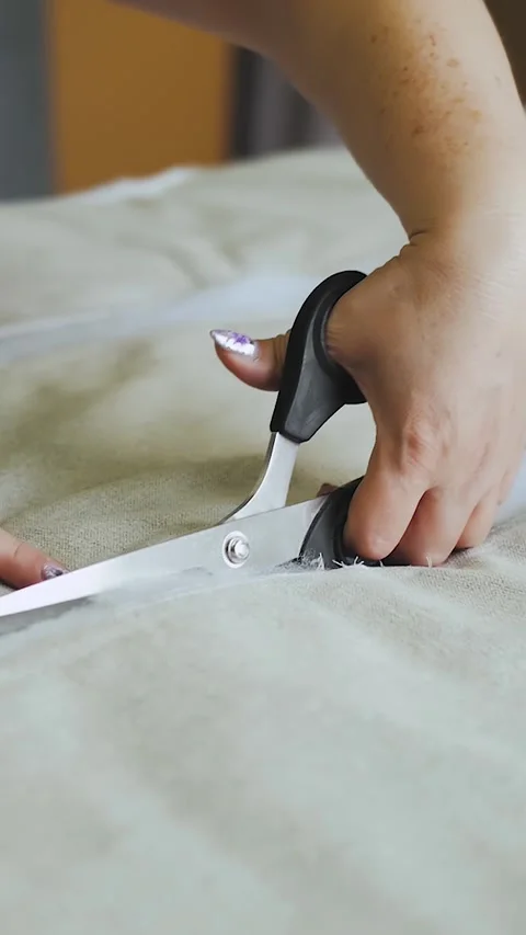 Vertical video. Close-up of female hands cutting foam rubber with scissors on Stock Footage 323451157