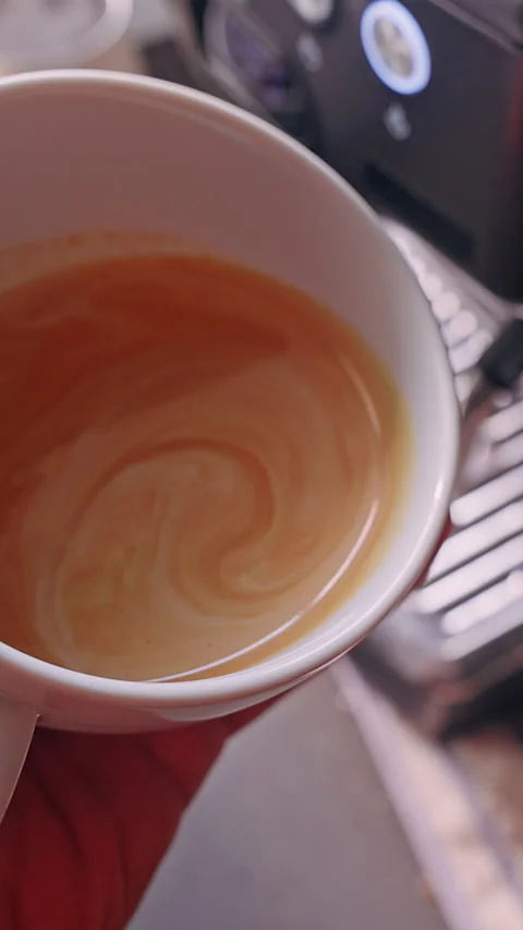 Vertical video. Close Up First Person View Pouring Steamed Milk Into Espresso Cr Stock Footage 331023777