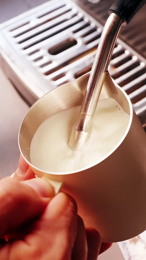 Vertical video. Close Up First Person View Frothing Milk In Metal Pitcher With S Stock Footage 331025537