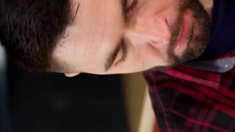 Vertical video. Close up. Hungry young brunette man eating chicken wings. Video stock 254488680