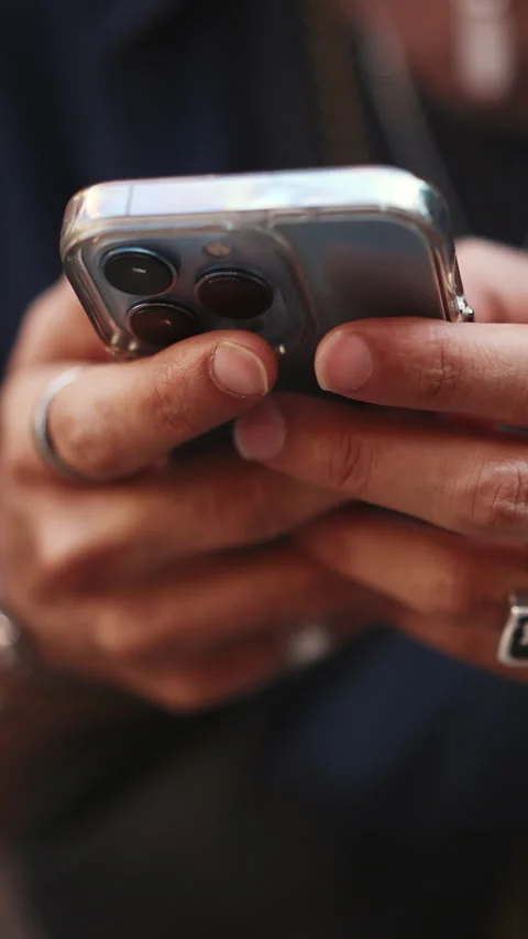 VERTICAL VIDEO: Close-up of male hands in bracelets and rings browsing informati Video stock 226948497