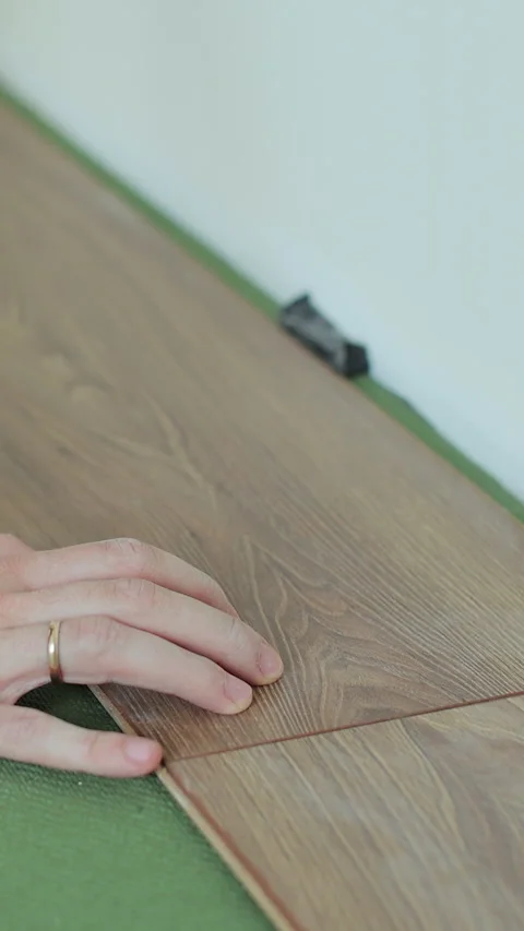 Vertical video Close-up of a man in an apartment laying laminate on the floor. 스톡 동영상 339060332