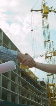 Vertical video. Close up Man architects engineers and male client shaking han Stock Photos