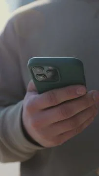 Vertical video. Close up of a man drinking to go coffee and browsing smartp.. Stock Photos