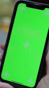 Vertical video. Close up of man hands using green screen smartphone in the .. Stock Photos