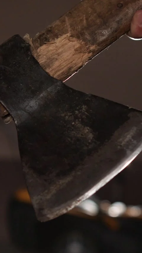 Vertical video close up of man holding old axe in garage with tools stored Stock Footage 287914460