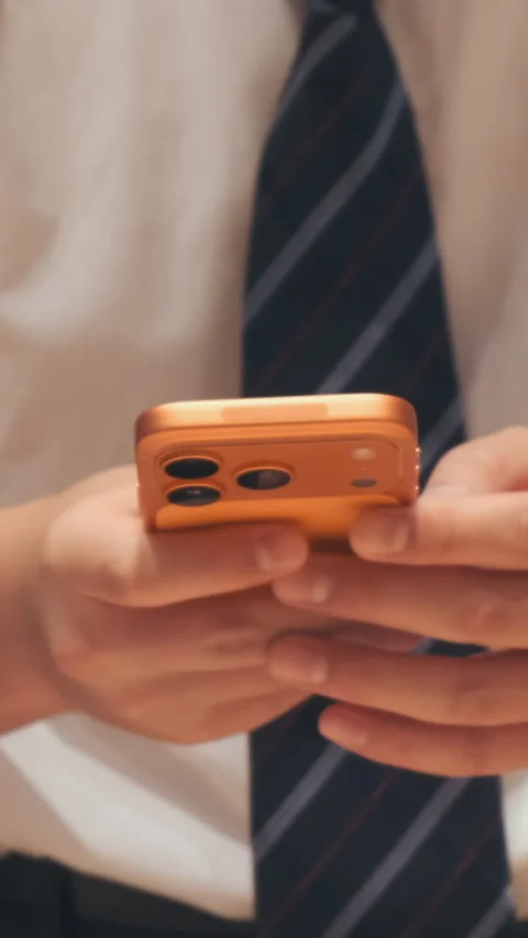 Vertical video: Close-up, man holding orange phone in electronics store Stock Footage 322515356