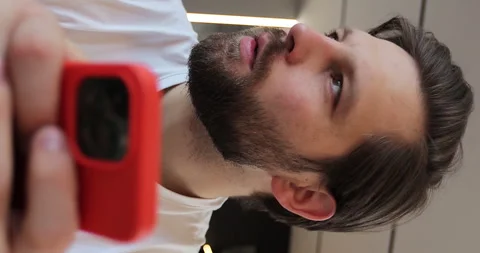 Vertical video: Close-up man using smartphone while sitting on couch using app Stock Footage 271233916