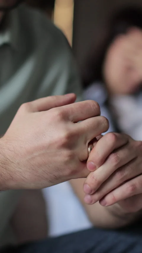 Vertical video Close up a man wiggles his wedding ring on his finger Stock Footage 337650057