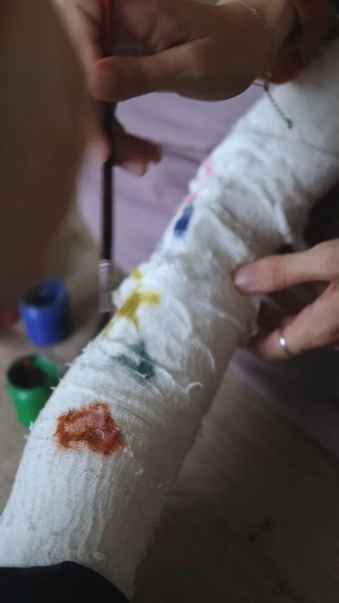 Vertical video, close-up of mother drawing on son's cast 스톡 동영상 234828562