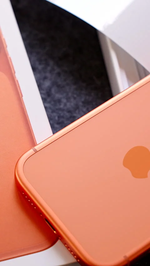 Vertical video. Close Up of Orange iPhone 17 Pro with Box and Packaging on Dark Stock Footage 317695825