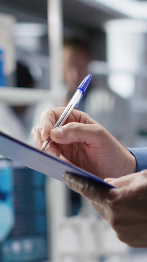 Vertical Video Close up of papers used to check on chemical data during lab work Stock Footage 318192608