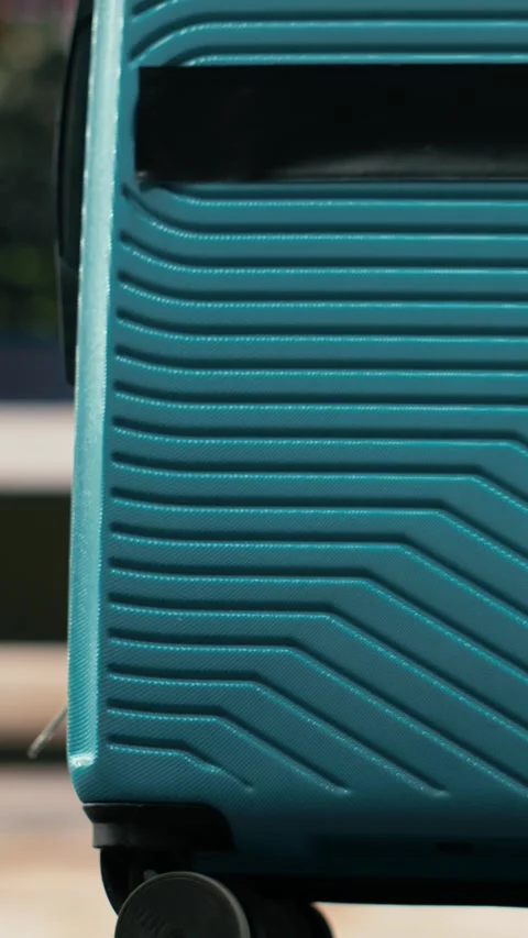 Vertical video Close up of passenger pulling trolley luggage across bus station Stock Footage 340206227