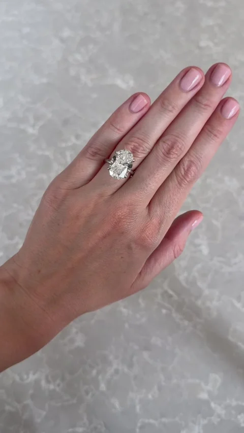 Vertical video close up of platinum oval diamond engagement ring with marble Stock Footage 316813242