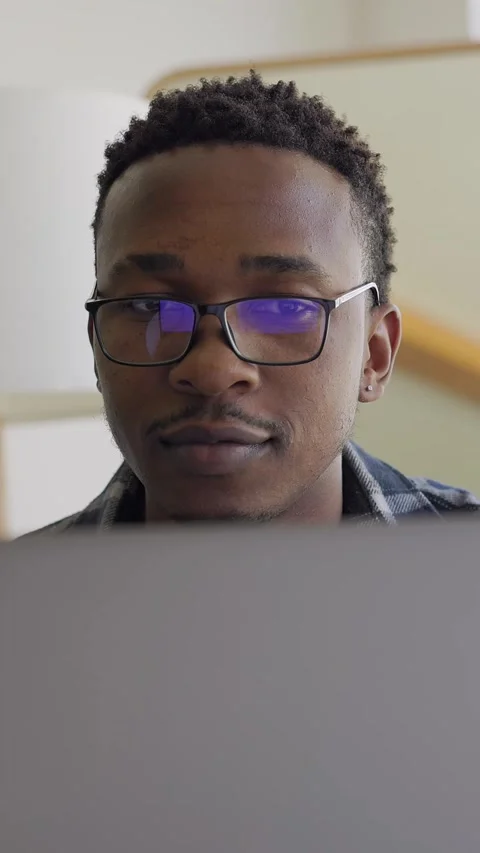 Vertical Video: Close up portrait of a young African American man work at laptop Stock Footage 315313373