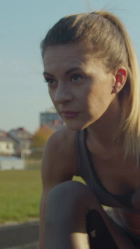 Vertical video. Close up. Pretty sporty woman running in the sports stadium. Stock-Footage 342913175