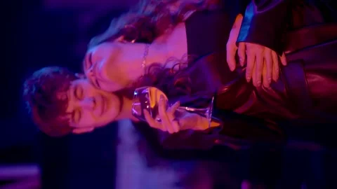 Vertical video. Close-up of a sensual couple flirting, kissing under neon lights Vídeo Stock 174401337