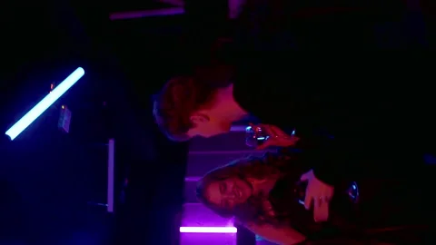 Vertical video. Close-up of a sensual couple flirting, kissing under neon lights Vídeo Stock 202007922