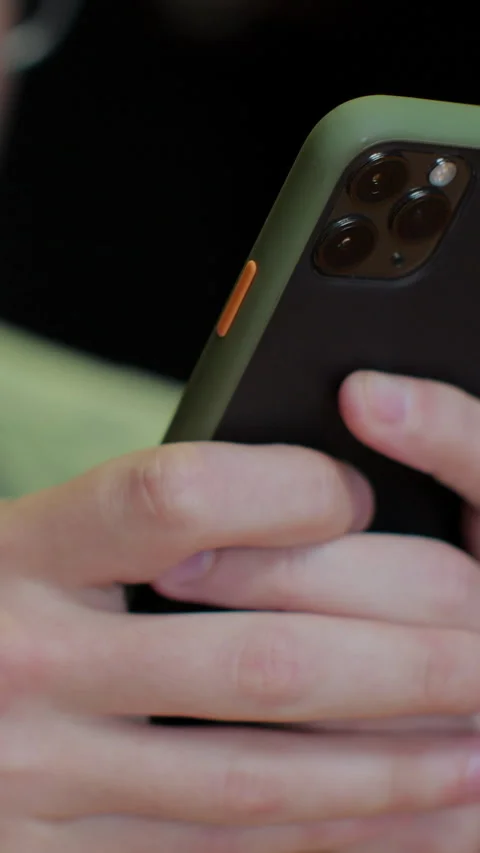 Vertical video. Close up shot of man hands using smartphone in cafe. Stock Footage 345237411