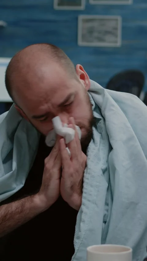 Vertical video: Close up of sick man blowing runny nose with tissues Stock Footage 219468986